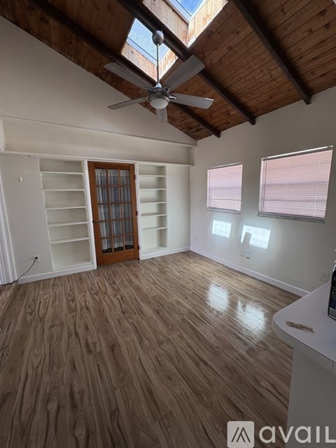 A room with wooden floors and a ceiling fan.