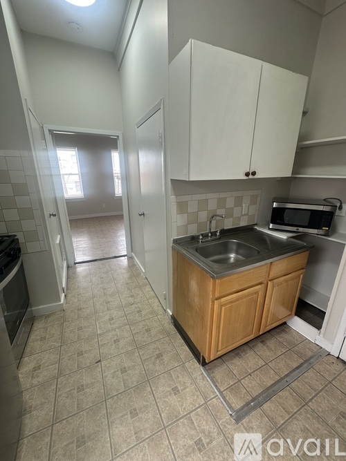 A kitchen with a sink and a microwave.