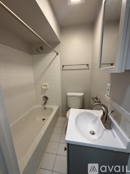 A room with tiled flooring and two windows.