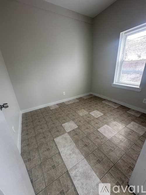A room with a tiled floor and a window letting in light.