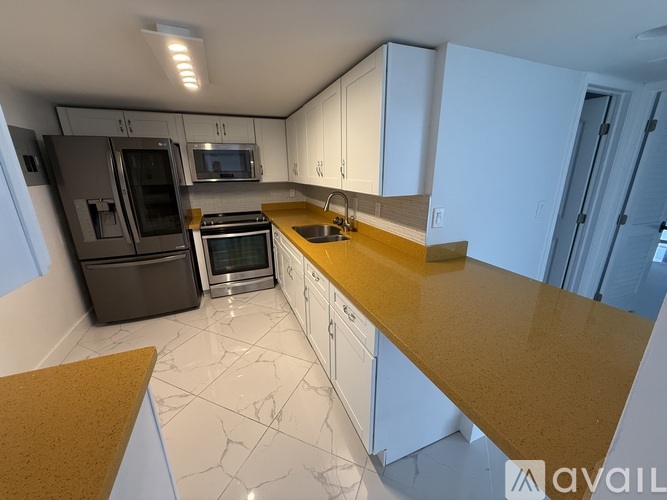 A kitchen with white cabinets and a yellow countertop.