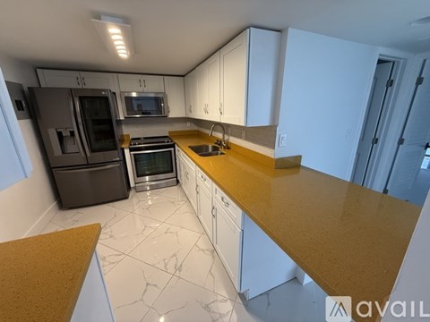 A kitchen with white cabinets and a yellow countertop.