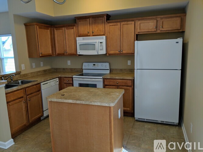 A kitchen with wooden cabinets and a white refrigerator.