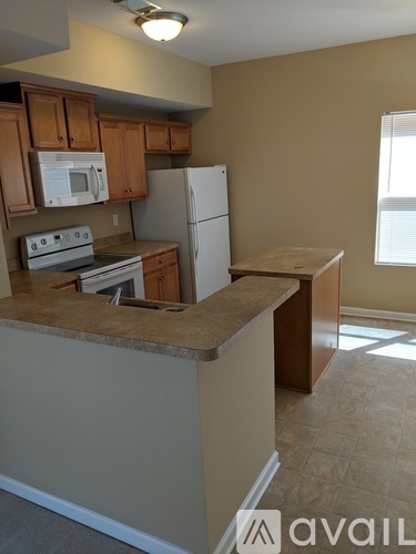 A kitchen with brown cabinets and a white refrigerator.
