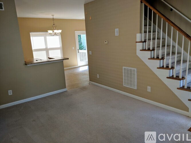 A spacious room with a staircase leading to the upper floor.