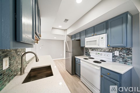 A kitchen with a sink and a stove top oven.