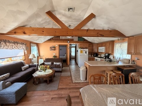 A living room with a couch, coffee table, and a dining table with chairs.