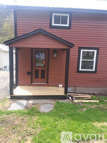 A red house with a brown door and a window.