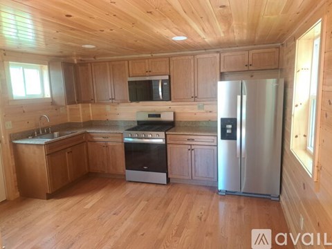 A kitchen with wooden cabinets and a stainless steel refrigerator.