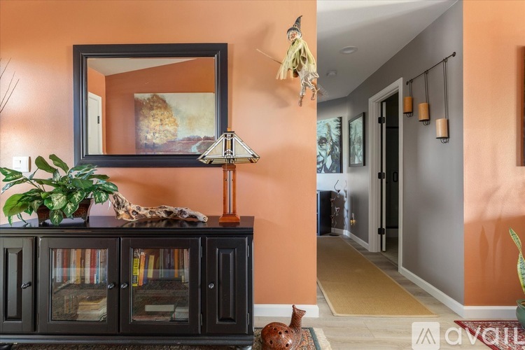A living room with a black cabinet and a framed picture on the wall.