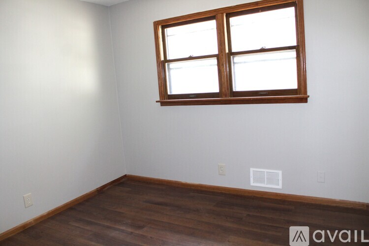 A room with a wooden floor and a window.