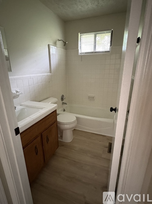 A bathroom with a toilet, sink, and bathtub.