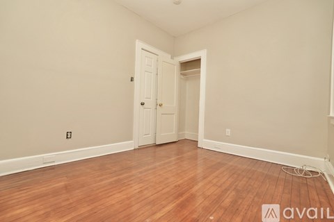 A room with a wooden floor and a white door.