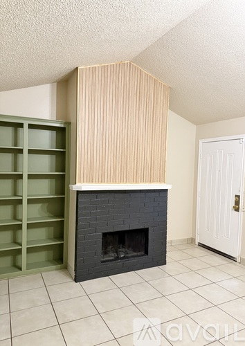 A fireplace with a white door and a green cabinet.