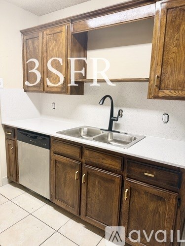 A kitchen with wooden cabinets and a white countertop.