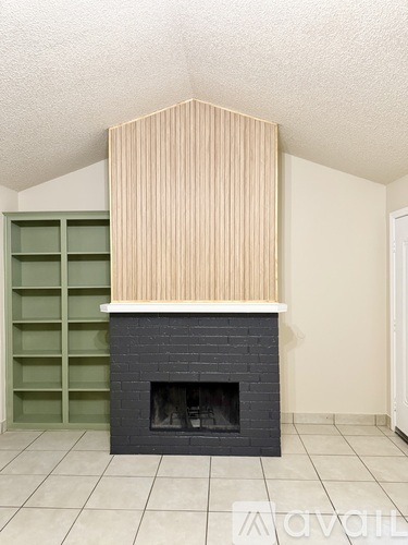 A fireplace with a wooden hood above it in a room.