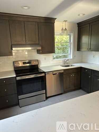 A kitchen with dark brown cabinets and stainless steel appliances.