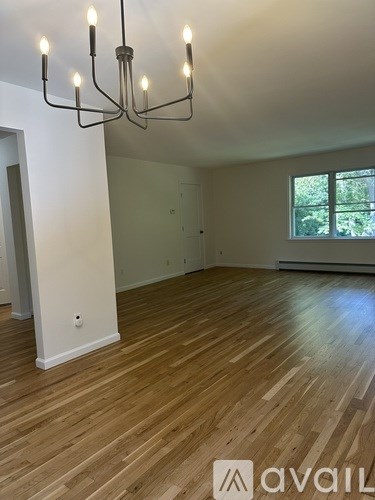 A room with wooden floors and a chandelier.