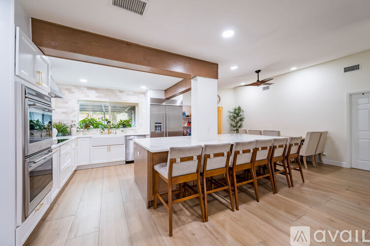 A kitchen with a long table and chairs.