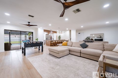 A spacious living room with a pool table and a large sectional sofa.