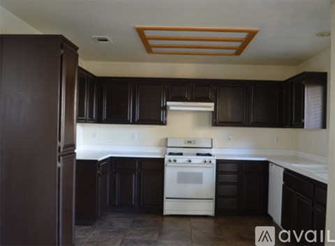 A kitchen with a white stove top oven and black cabinets.