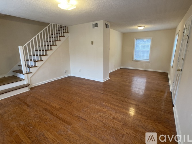 A room with wooden flooring and a staircase.