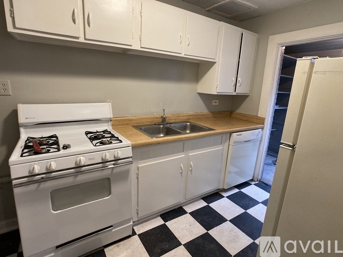 A kitchen with a white stove and cabinets.