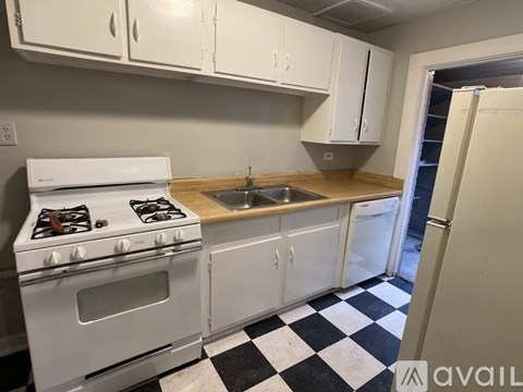 A kitchen with a white stove and cabinets.