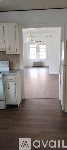 A kitchen with white cabinets and a refrigerator.