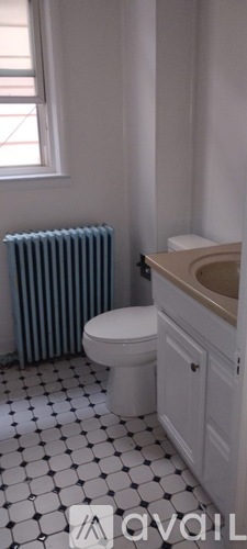 A bathroom with a toilet, sink, and a radiator.