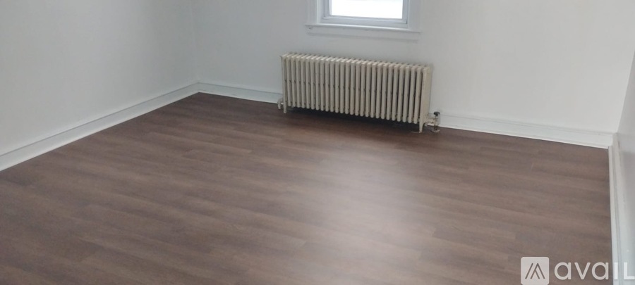 A room with wooden flooring and a radiator.