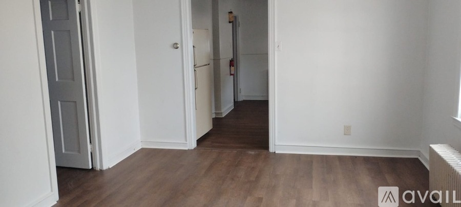A room with a door and a refrigerator.
