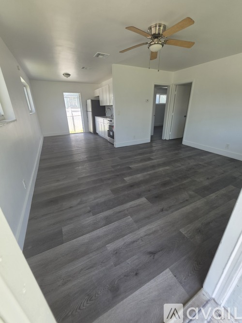 A room with a ceiling fan and wooden flooring.