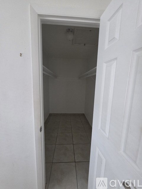 A kitchen with white cabinets and a wooden floor.