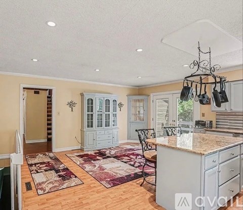 A kitchen with a large island and a dining table with chairs.