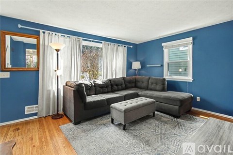 A living room with a grey sofa and ottoman.