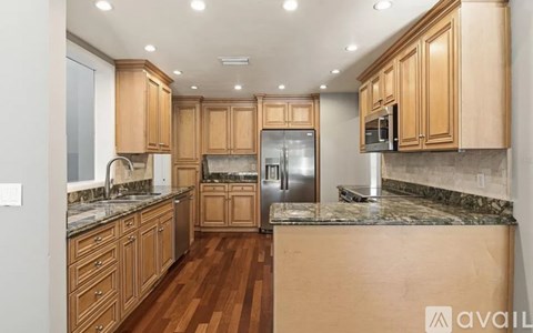 A kitchen with wooden cabinets and a marble countertop.