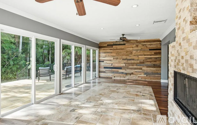 A modern living room with a stone floor and a fireplace.