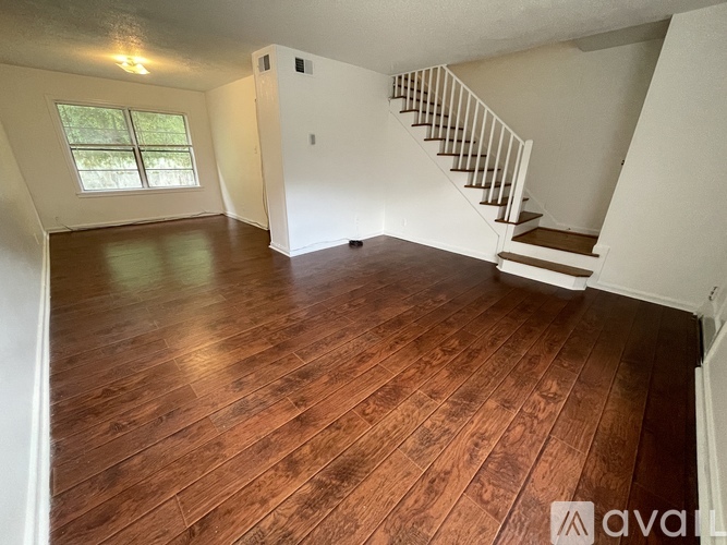 A room with wooden flooring and a staircase.