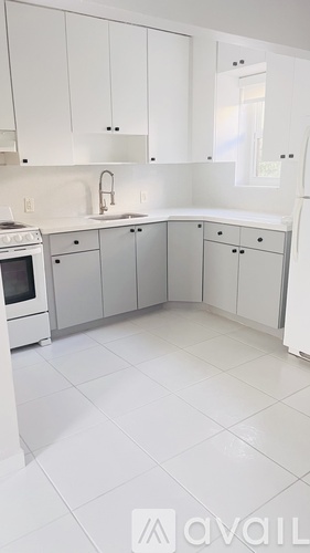 A kitchen with white cabinets and appliances.