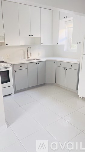 A kitchen with white cabinets and appliances.