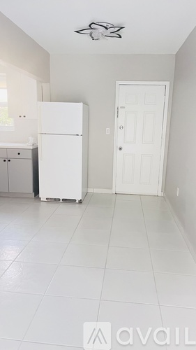 A kitchen with a white fridge and a white door.