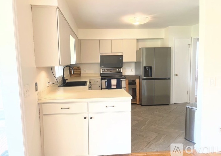 A kitchen with white cabinets and appliances.