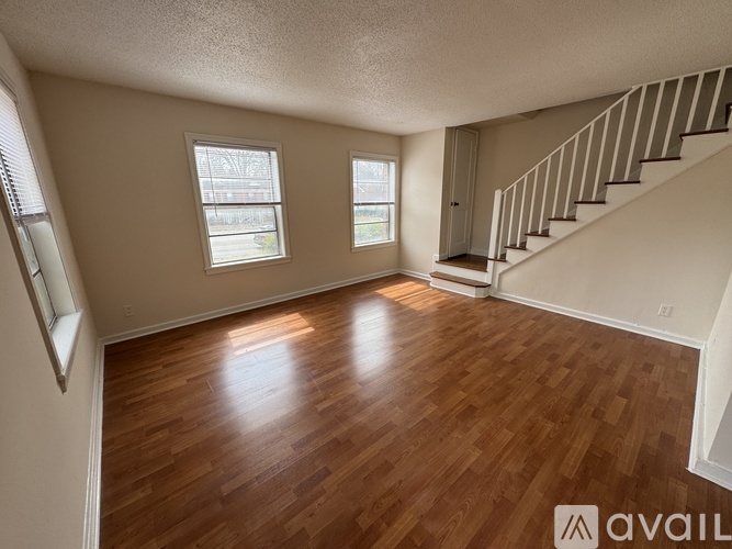 A room with wooden floors and a staircase.
