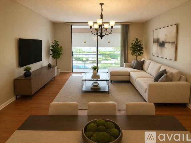 A living room with a large couch, a coffee table, and a chandelier.