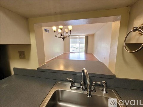 A kitchen with a stainless steel sink and a chandelier.