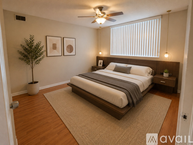 A bedroom with a bed, a ceiling fan, and a potted plant.