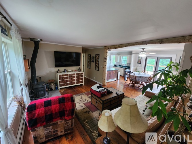 A living room with a red and black plaid ottoman.
