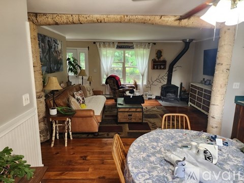 A living room with a couch, chair, and a table with a blue tablecloth on it.