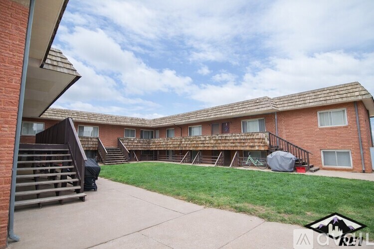 A brick building with a green lawn in front.